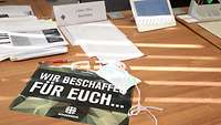 A banner with the slogan “We procure for you” is lying on the desk of the central Coronavirus point of contact.
