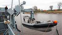 The Gecko rescue boat hanging from a launching device, ready for launch