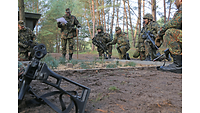 Several soldiers at the sand table