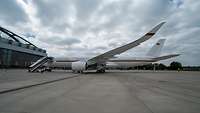 Der Regierungsflieger Airbus A350-900 steht in Parkposition mit angedockter Gangway vor einem Hangar der Lufthansa.