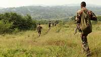 Afrikanische Soldaten laufen durch die Steppe 