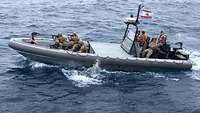 Der UNIFIL Force Commander sitzt auf einem Boot, im vorderen Bereich des Bootes ist ein Boardingteam der Libanesen