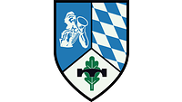 Im silbern-blau geteilten Wappen rechts ein Pionier, links ein Edelweiß, darüber eine Pionierbrücke.