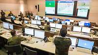 Ein Raum mit vielen Monitoren und Soldaten 