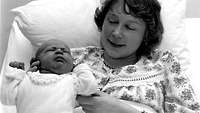 Frau mit ihrem Baby in einem Krankenhausbett