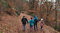 Eine Familie mit zwei Kindern beim Wanderm im Wald