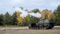Eine Panzerhaubitze 2000 schießt scharf auf dem Truppenübungsplatz, weißer Rauch entsteht