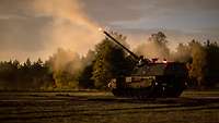 Eine Panzerhaubitze schießt auf dem Truppenübungsplatz bei Nacht