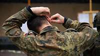 Ein Soldat führt sich Gehörschutzstopfen ein