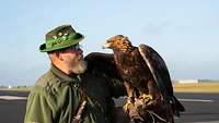 Einer der eingeladenen Falkner mit seinem Steinadler auf dem Arm.