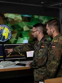 soldiers look at a monitor
