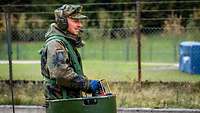 A soldier standing in a green tube with his hands on a control console