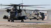 Zwei Hubschrauber vom Typ CH-53 rollen hintereinander über das Flugfeld