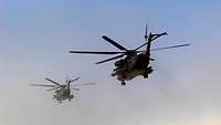 Zwei Hubschrauber vom Typ CH-53, von unten gesehen, in der Luft