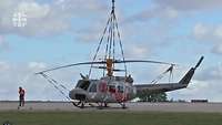Ein Hubschrauber vom Typ Bell UH-1D am Boden ist an einem Gehänge befestigt