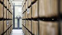 A corridor with countless hanging file folders on the left and right, in floor-to-ceiling shelves