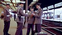 Ein Feldjäger kontrolliert die Dienstausweise zweier Soldaten auf dem Bahnhof
