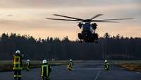 Militärische Brandschutzkräfte warten auf den Transporthubschrauber CH-53