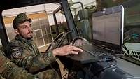 a soldier in a car with an computer