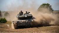 A Leopard battle tank drives through the terrain