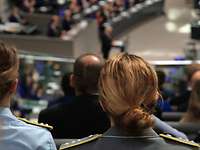 Two officers during a visit to the Bundestag. They are listening to a speech.