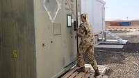 Eine Soldatin öffnet die Tür des Containers zur Waffenkammer