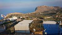 Mehrere Arbeitscontainer stehen zusammen auf einem Berg des NATO-Schießplatzes auf Kreta.