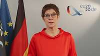 Annegret Kramp-Karrenbauer vor den Flaggen Deutschlands und der EU