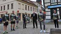 Fünf Soldaten in Bundeswehr-Laufshirts und zwei Zivilisten stehen auf dem Marktplatz vom Havelberg.