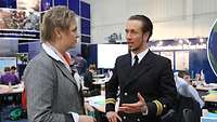 Ein Soldat und eine Frau im Gespräch an einem Messestand