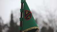 Ein grüner Wimpel hängt an einem Flaggenstab.