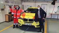 Militärpfarrer Tim Mahle (rechts) übergibt Stabsfeldwebel Jörg May ein kleines Wandkreuz für die Rettungswache