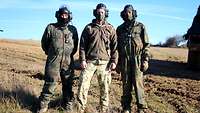 Gruppenfoto mit drei ungarischen Soldaten in Tarnuniformen und Panzersprechhauben.