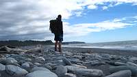 Axel Schönborn steht an einem Stein-Strand und blickt in die Ferne