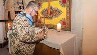 Der Gottesdienst wird durch den Pfarrhelfer vorbereitet, er entzündet eine der vielen Kerzen am Altar