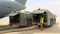 Ein Soldat arbeitet am Flugfeldtankwagen, der mit einem zweiten Tankwagen neben dem A400M steht