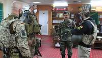 Zwei deutsche Soldaten unterhalten sich in einem Büro mit zwei afghanischen Soldaten 