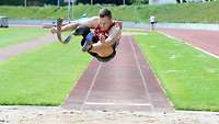 Athlete with prosthetic leg doing the long jump