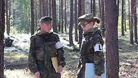 Zwei Soldaten stehen in einem Wald und besprechen ihr weiteres Vorgehen.