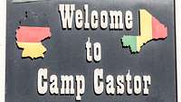 Ein Schild, auf dem „Welcome to Camp Castor“ steht, rechts und links die Umrisse Deutschlands und Malis in Landesfarben