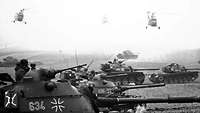 Black-and-white photo of M 48 main battle tanks and Sikorsky H-34 G helicopters during the "Panthersprung" maneuver