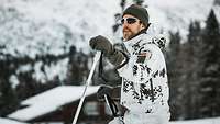 Ein Soldat in Schneetarnuniform steht auf Skiern am verschneiten Waldhang der bayerischen Reiteralpe.