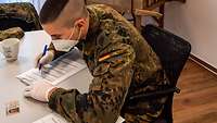 Soldat trägt Daten in ein Formular ein. 