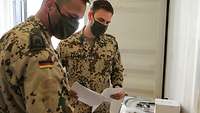 Zwei Soldaten prüfen die Ausrüstung anhand einer Liste