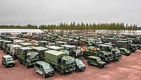 Neben- und hintereinander stehen zahlreiche Militärfahrzeuge auf einem fußballfeldgroßen Platz.