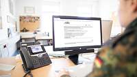 Eine Soldatin sitzt vor dem Bildschirm auf dem die erste Frage der Online-Studie angezeigt wird
