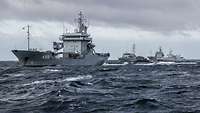 Mehrere militärische Boote fahren hintereinander auf See.