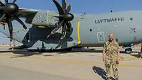 Ein Soldat steht vor einem grauen Transportflugzeug A400M