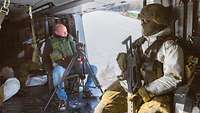 Ein Kamermann sitzt mit den Soldatinnen und Soldaten des Aufklärungslehrbataillons 3 im Transporthuschrauber und filmt.