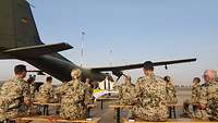 Militärpfarrer Jörg Plümper feiert mit Soldaten einen Gottesdienst vor einer Transall in Niamey